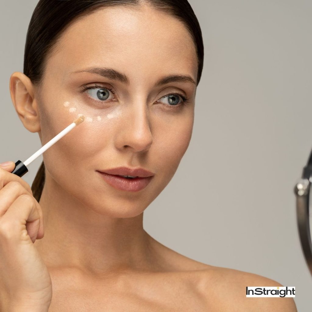a woman applying a concealer